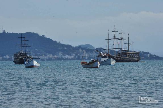 Barcos e escunas para turistas ficam ancorados na baía de Ponta das Canas, praia no norte de Florianópolis, Santa Catarina